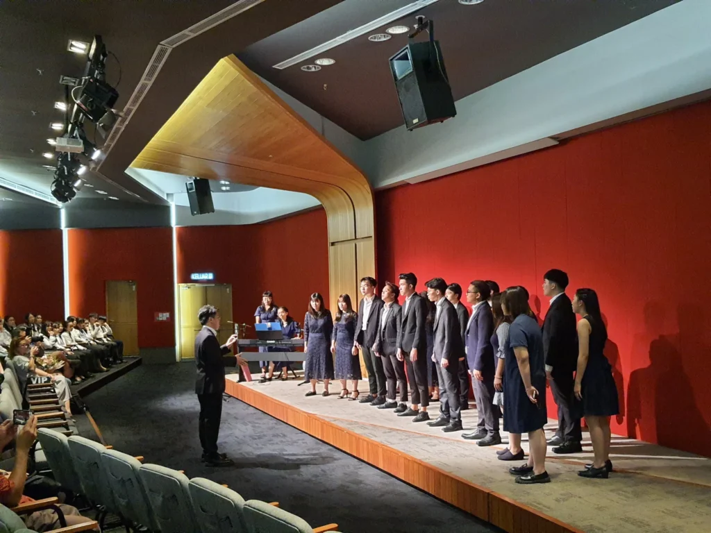 Choir lined up on the Theatrette stage at the Elysian Concert, seen from the side