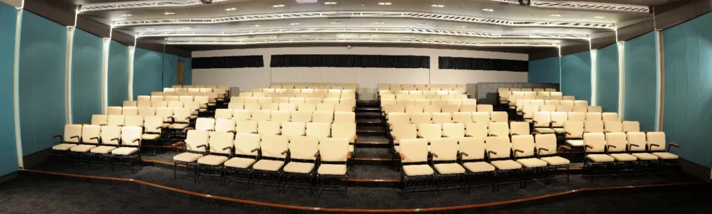 Wide view of the empty tiered seating in a Theatrette with blue walls