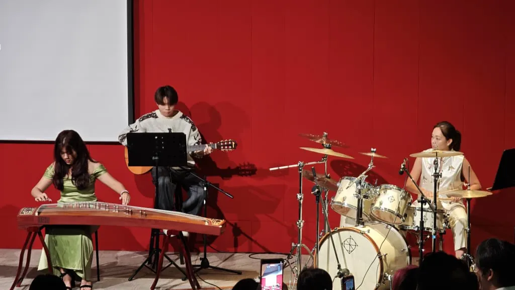 Guzheng, guitar and drum players performing at a music academy recital in a Theatrette