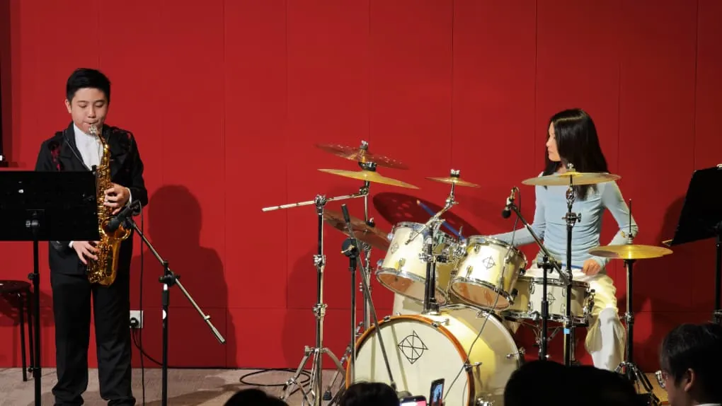 Saxophone and drum duo at a music academy recital in a Theatrette