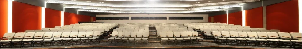 Wide view of the tiered seating in a Theatrette with red walls