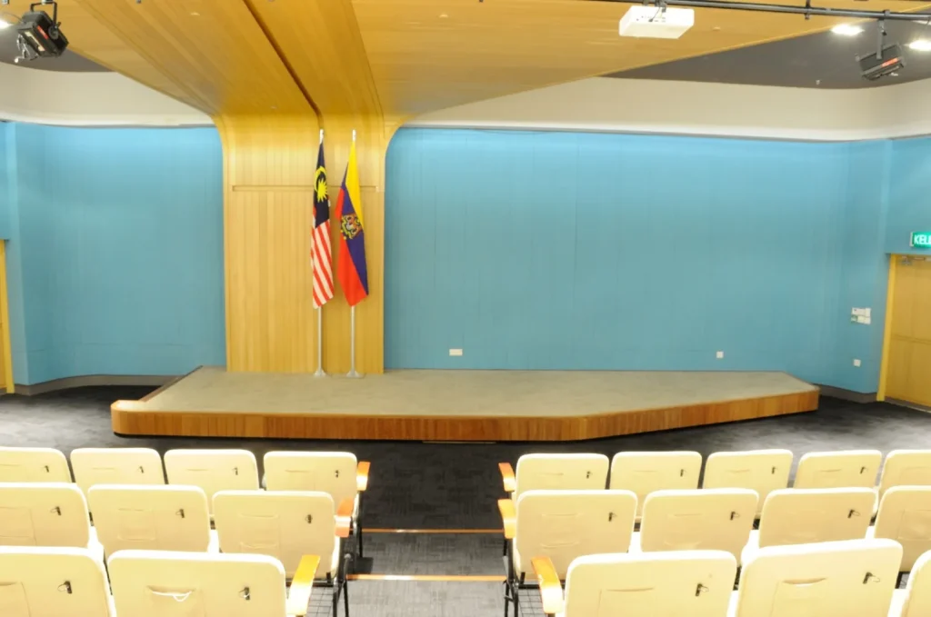 Empty Theatrette stage with flags, blue walls and front-row seats